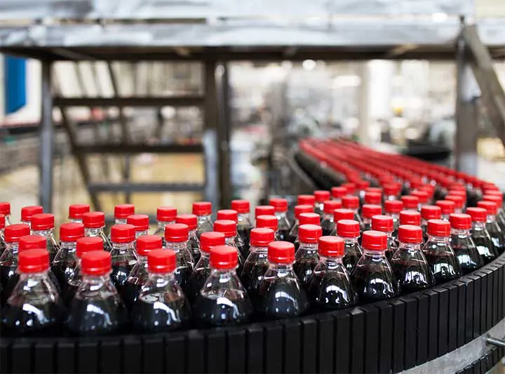 Carbonated soft drink bottles on a curved conveyor