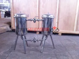 Paired stainless steel filtration vessels in a workshop