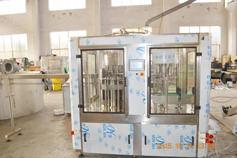Front view of a compact enclosed filling machine in the workshop