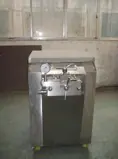 Compact homogenizer cabinet beneath a stainless steel tank