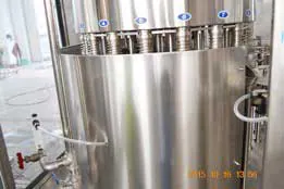 Numbered cooking oil filling heads beside a stainless steel product tank