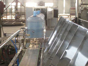 Large blue container beside a washing machine conveyor