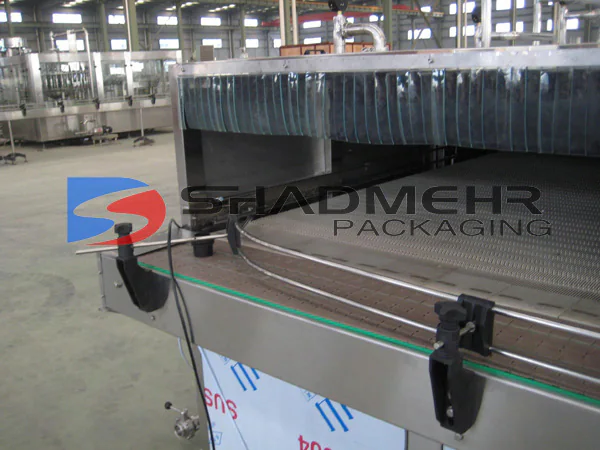 Bottle conveyor entering a stainless steel shower cooling system